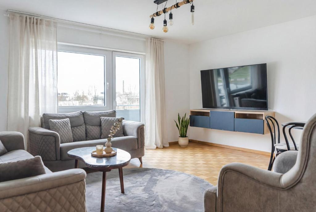 a living room with a couch and a tv at Dreiländer-Blick Apartment 2 Schlafzimmer in Lörrach