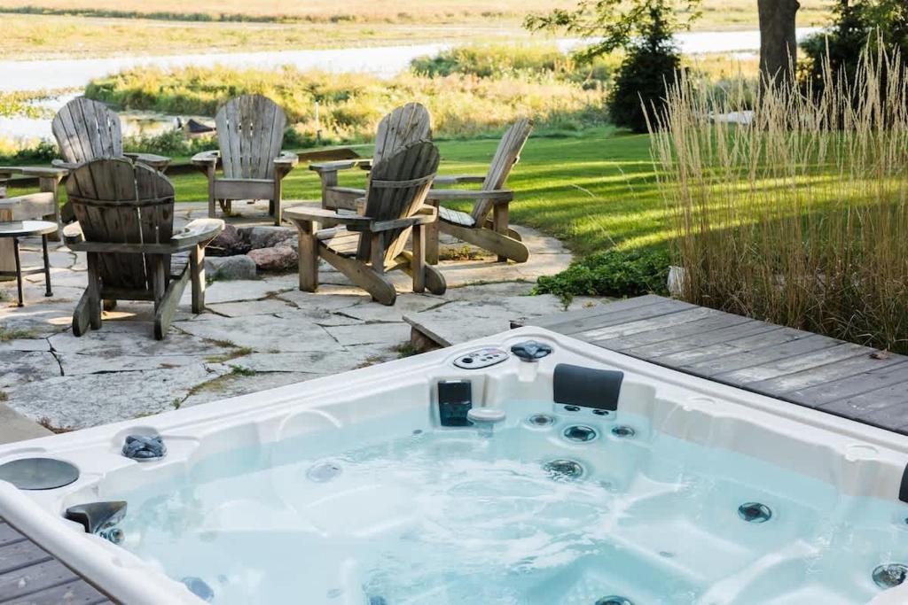 a hot tub in a yard with chairs and a table at The Great Escape Blocks From Your Private Beach in New Buffalo