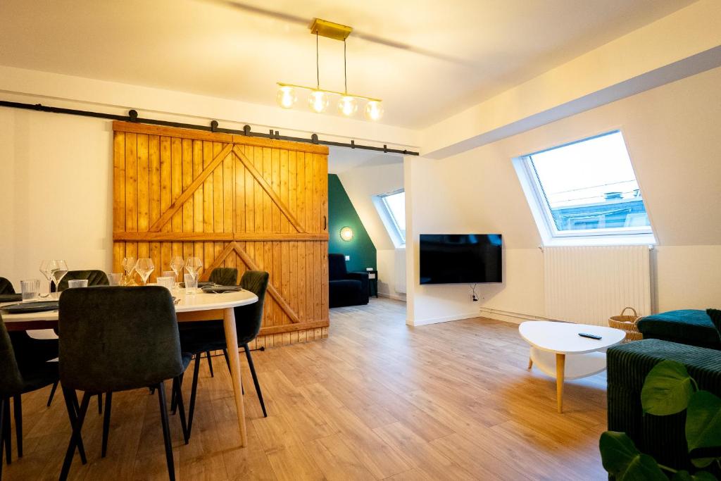a living room with a dining table and a tv at Le #7 - Centre ville - Parking privé - Balcon in Saint-Omer