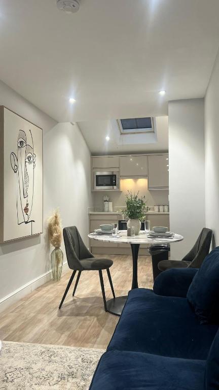 a living room with a table and chairs and a kitchen at The perfect one bed stay in Central Station