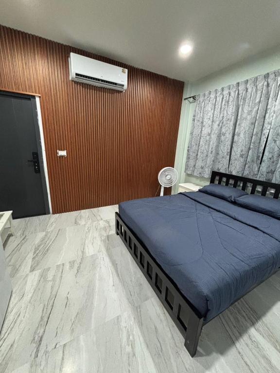 a bedroom with a bed with blue sheets and a window at KaizaHotel Suvarnabhumi Airport in Lat Krabang
