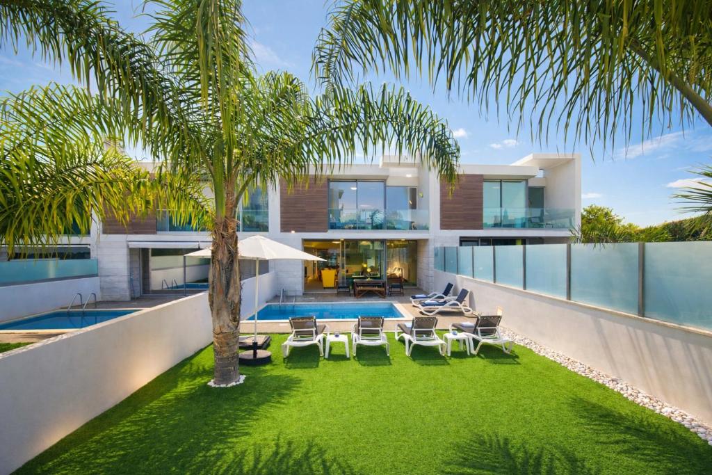 an image of a house with a yard with chairs and a swimming pool at Moon - Private Pool - 8 Guests - Albufeira in Albufeira