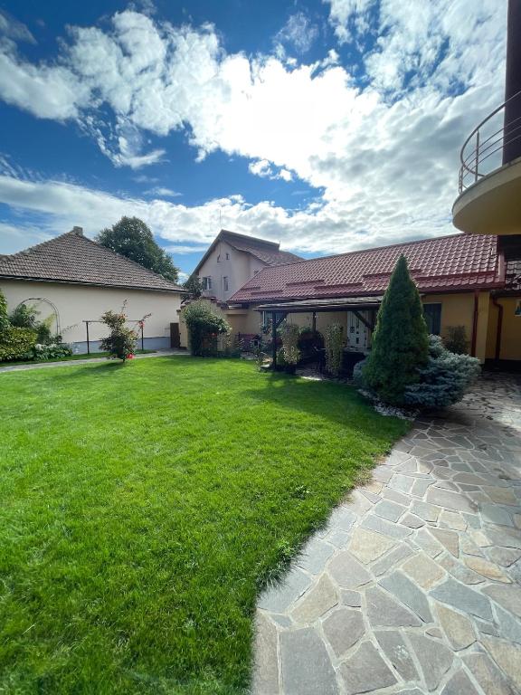 a house with a green yard with a building at Casa Eden in Baia Mare