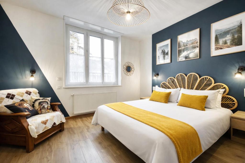 a bedroom with a large bed and a chair at Au jardin de la Basilique in Boulogne-sur-Mer