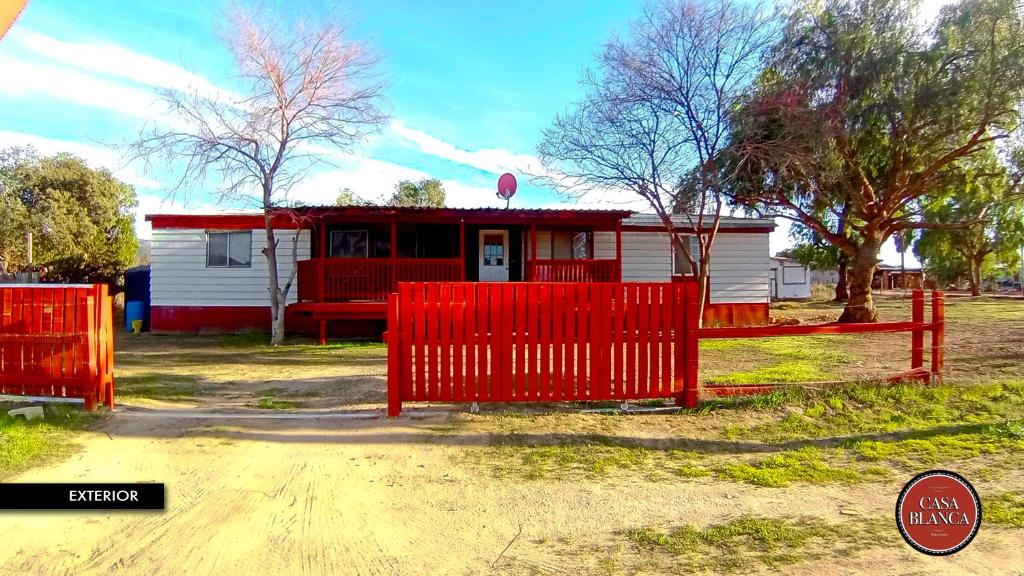 a red fence in front of a small house at Casa Blanca Hotel Campestre in Francisco Zarco