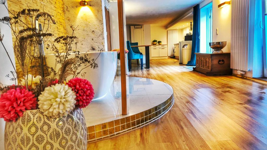 a living room with a vase with flowers in it at AMORE 66 bei Greta in Marl