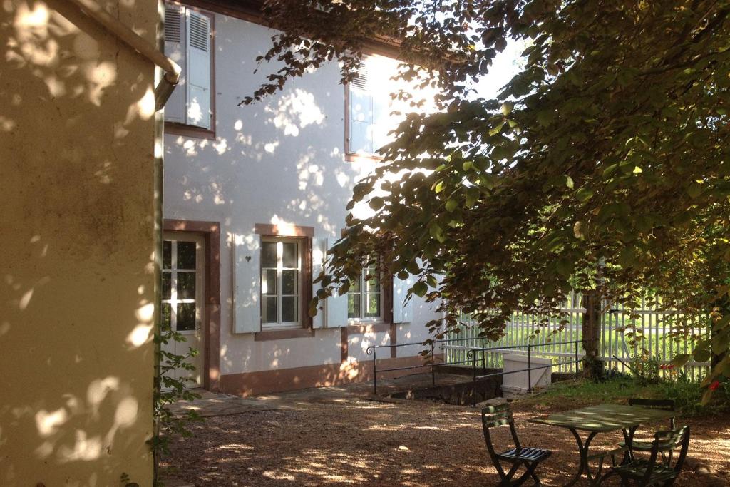 Una casa con una mesa y sillas delante de ella. en La Maison Carré, en Wolxheim
