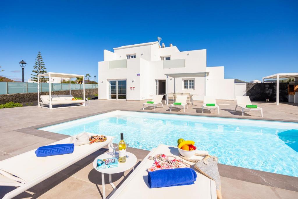 a villa with a swimming pool in front of a house at Villa Yaiza Secret 1 in Yaiza