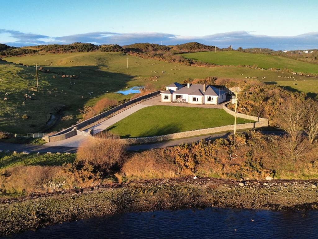 una vista aerea di una casa su una collina vicino all'acqua di Ranny Roe a Fanad
