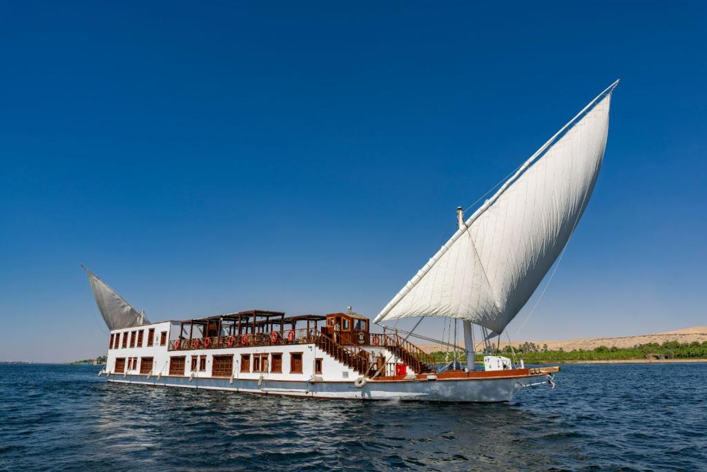 a boat with a large sail on the water at Princess Farida Luxury Dahabiya Nile Cruise, Every Monday from Luxor to Aswan 4 nights and Every Friday from Aswan to Luxor 3 nights in Luxor