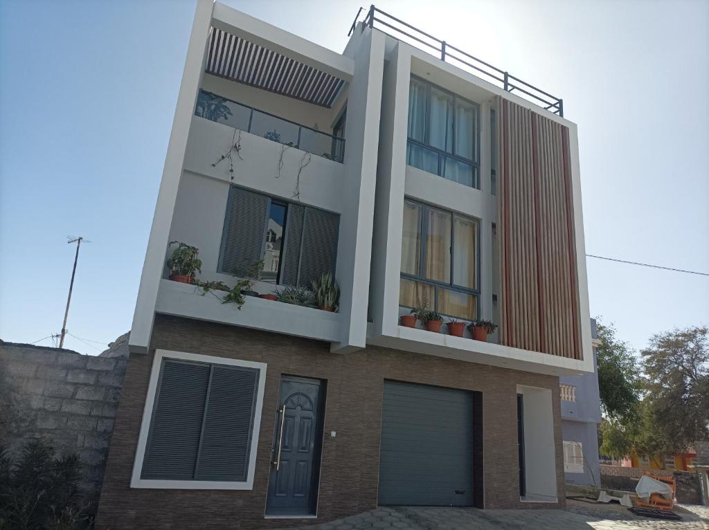 Una casa grande con un balcón en la parte superior. en LBranco, en Porto Novo