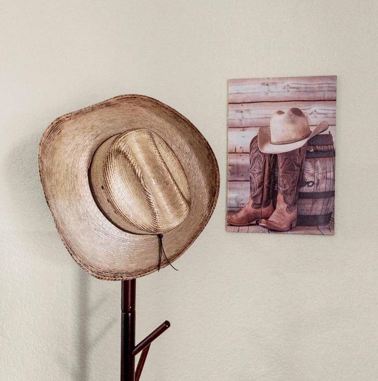 a hat on a stand next to a picture of a cowboy at Cowboy Hideout in Sedona