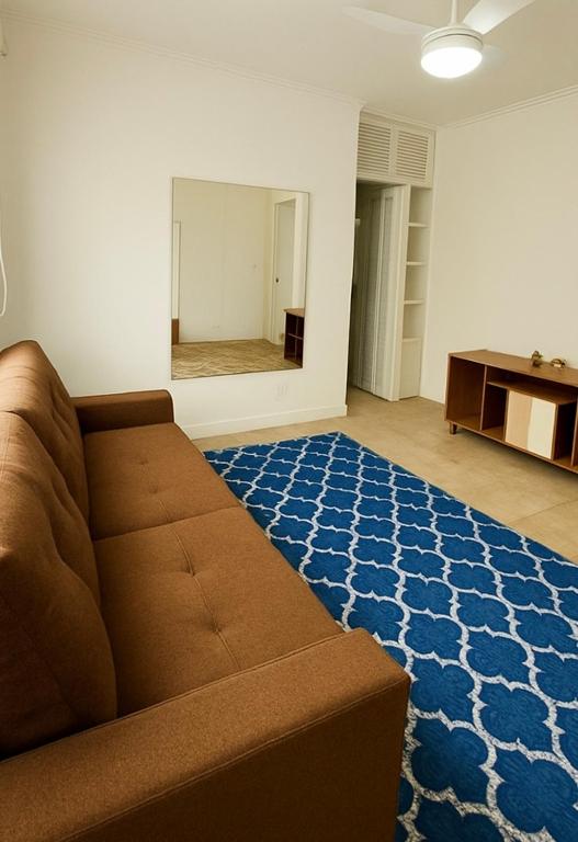 a living room with a couch and a blue rug at Apto 1 dormi in Capão da Canoa
