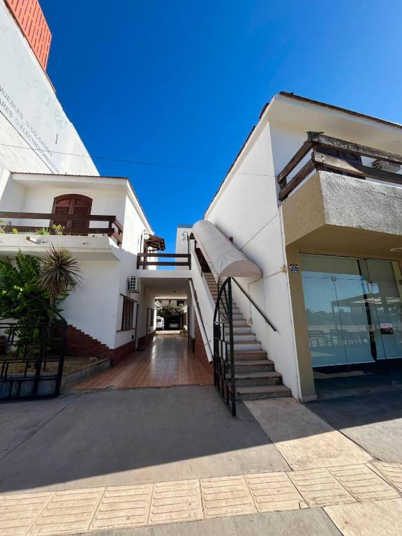 a white building with a staircase in front of it at Departamento espiral in Embalse