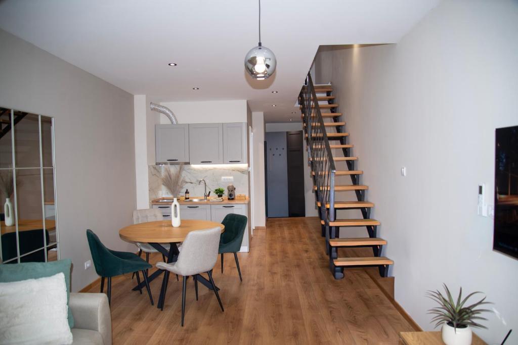 a kitchen and dining room with a spiral staircase in a apartment at PANTEX Centar Zlatibor in Zlatibor