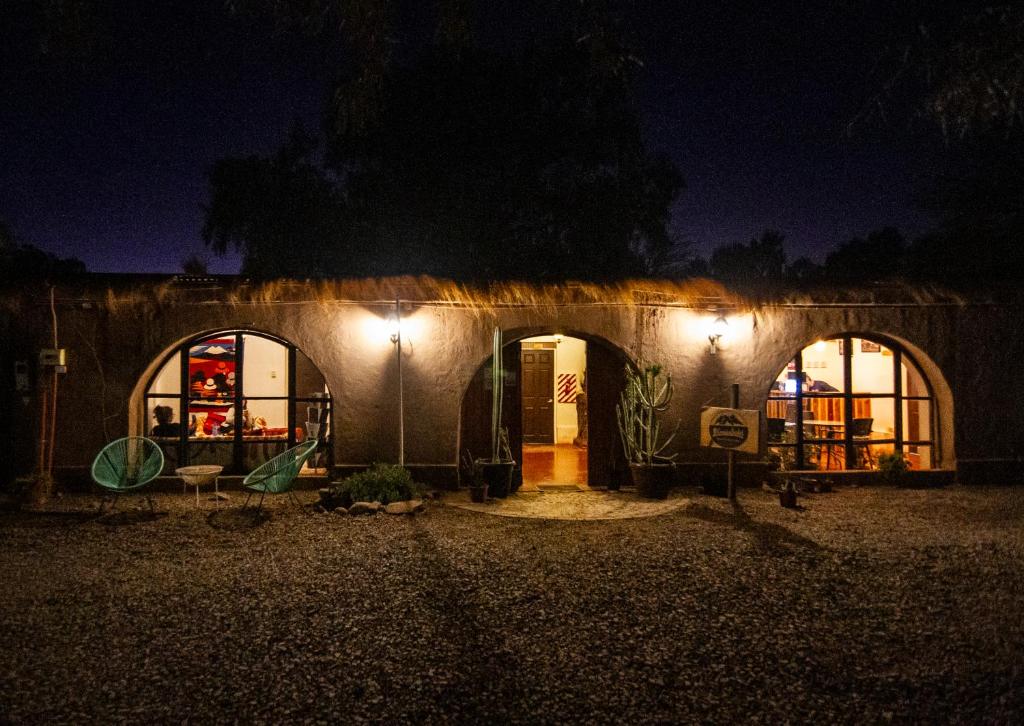 a building with two arched windows at night at CaminAndes Hostal in San Pedro de Atacama