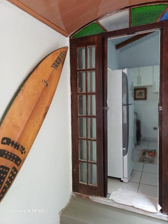 a surfboard hanging on a wall next to a window at Mar e descanso in São Sebastião