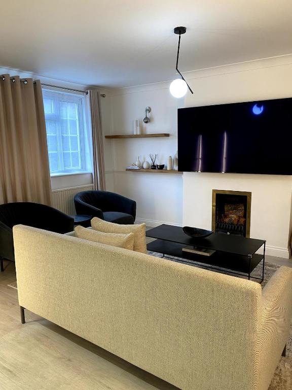 a living room with a couch and a fireplace at Luxury 2-Bed Apartment with Parking & Garden in Borehamwood