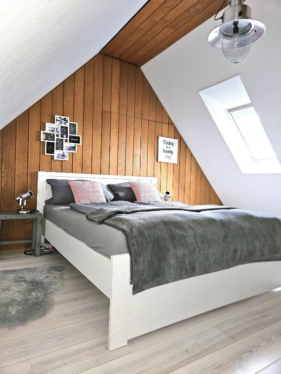 a bedroom with a white bed with wood paneling at Ferienwohnung 2 ANNA IFF in Würzburg
