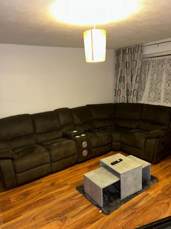 a living room with a brown couch and a table at Ivydale Guest House in Syston