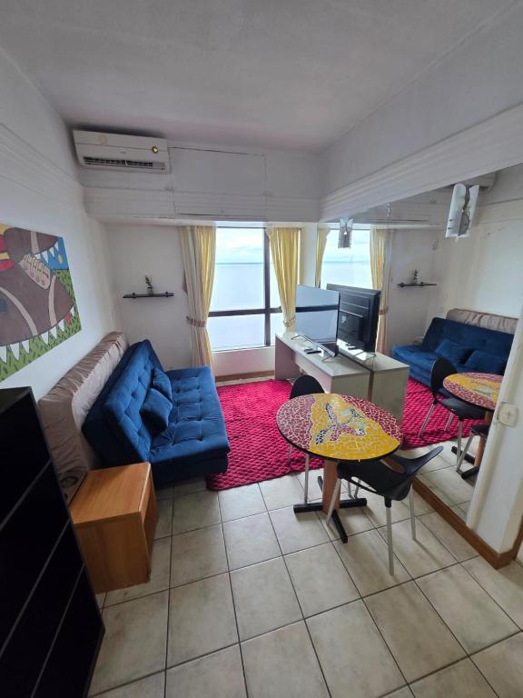 a living room with a blue couch and a table at tropical Flat Belissimo in Manaus