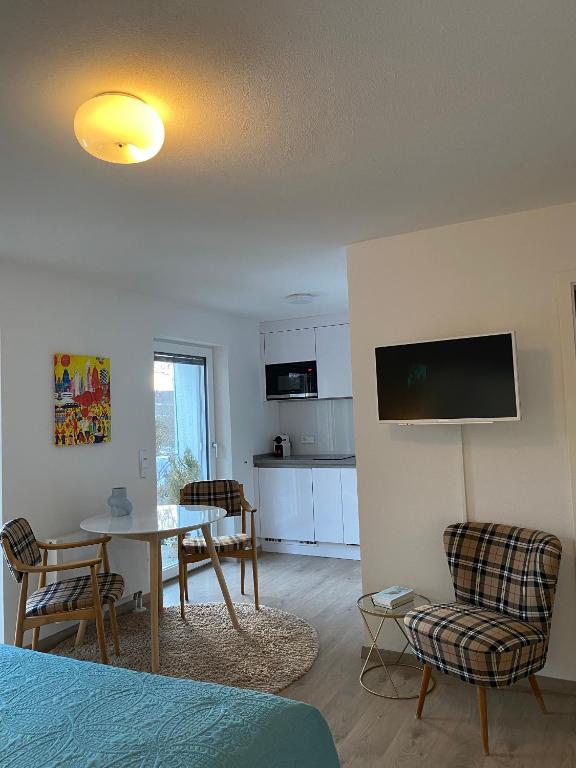 a living room with a table and chairs and a kitchen at Stilvolles Studio im Allgäu in Rettenbach am Auerberg