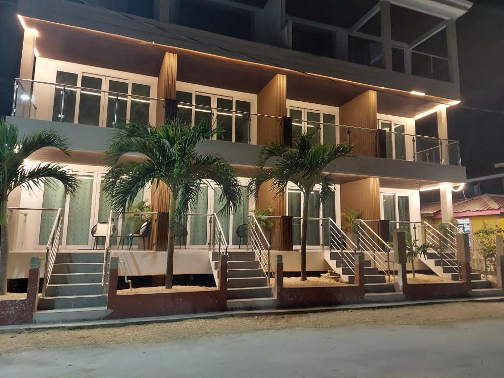 a building with palm trees in front of it at Caye Caulker Condos in Caye Caulker