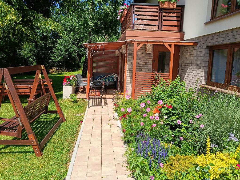 a garden with a bench and a house at Apartament in Rabka-Zdrój