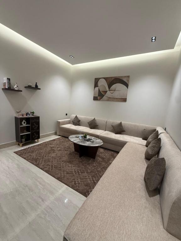 a living room with a couch and a coffee table at شقة فاخرة in Al Kharj