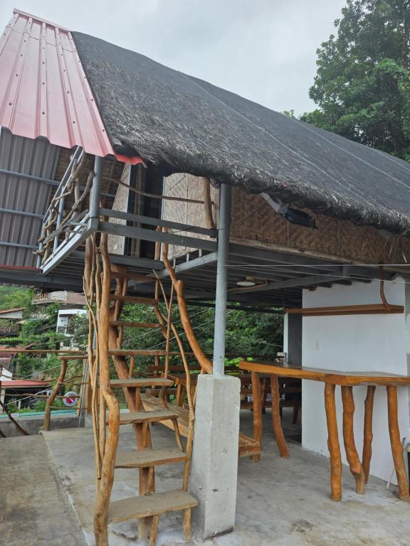 a hut with a bench and a table with a roof at Romantic Ocean View A-Frame with Shore Diving Access - Aloha Aina Dive Resort in Mabini