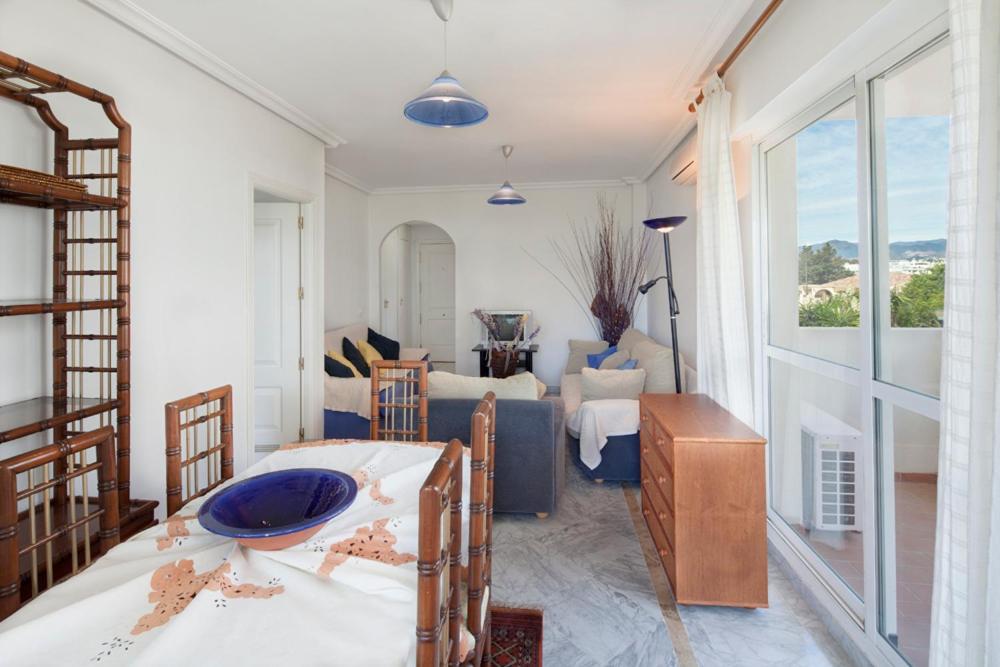 uma sala de estar com uma mesa e um sofá em Lorcrimar 3 em Marbella