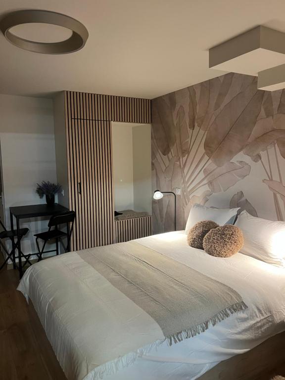 a bedroom with a large bed with two pillows on it at Luméa 126 in Éguilles
