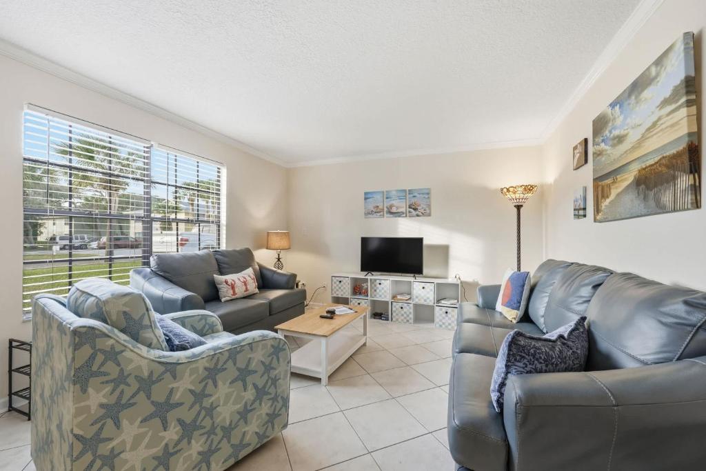 a living room with two couches and a tv at Fair Seas Clipper Condo for 6 in Saint Augustine Beach