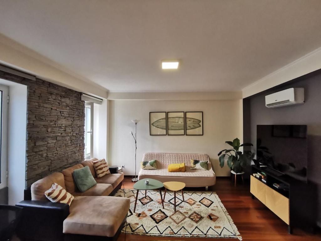 a living room with a couch and a tv at Surf Nest in Machico