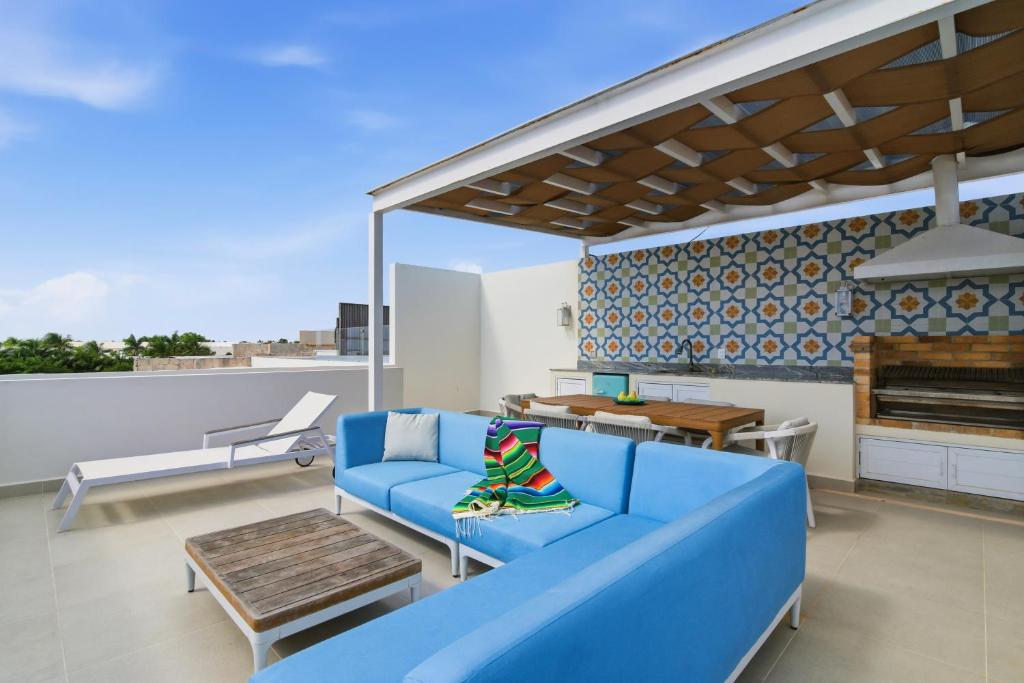 a living room with a blue couch and a piano at Ocean View Haven Walk to Beach Private Rooftop Terrace in Akumal