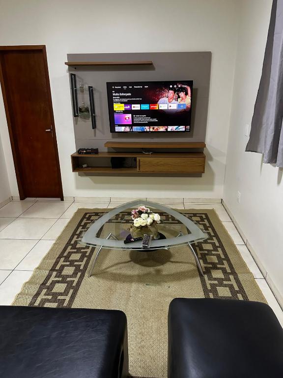a living room with a tv and a coffee table at Apt Aconchegante no Centro de Rolim in Rolim de Moura