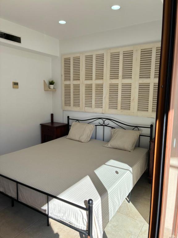 a bedroom with a bed and a window with shutters at Pollensa apartament in Pollença