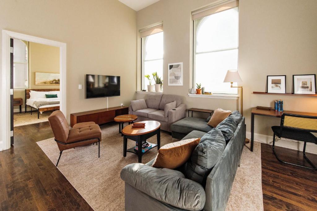 a living room with a couch and a tv at Downtown Luxe 2BR Loft Apt | Sleeps 8 | Walkable in Milwaukee