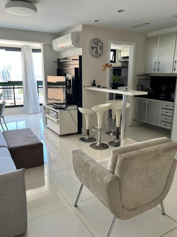 a kitchen and living room with a couch and a table at Enseada do Suá Golden Gate - Moderno e Espaçoso in Vitória