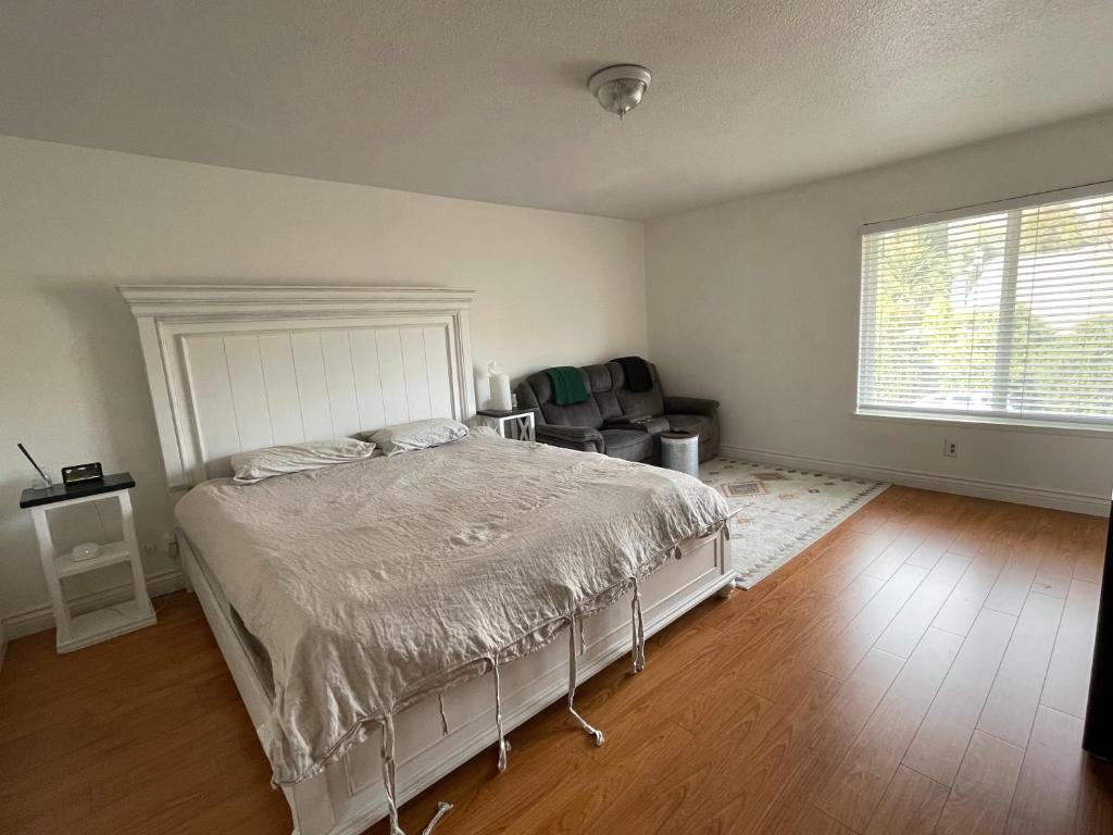 a bedroom with a bed and a chair and a window at LA Lux Suite with Private Bathroom in Santa Clarita