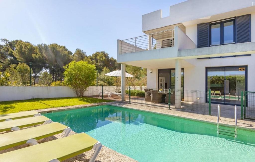 a house with a swimming pool in front of a house at Oasis N'aguait in Cala Ratjada