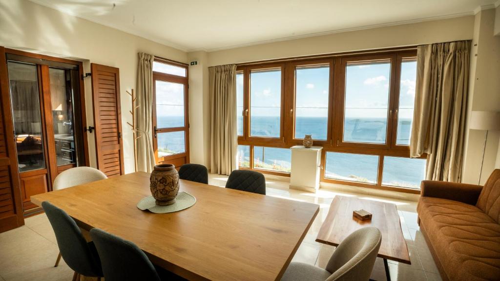 a living room with a table and chairs and a couch at Vignetta Mare 2BR Villa με Θέα & και Ιδιωτικό Πάρκινγκ in Ermoupoli