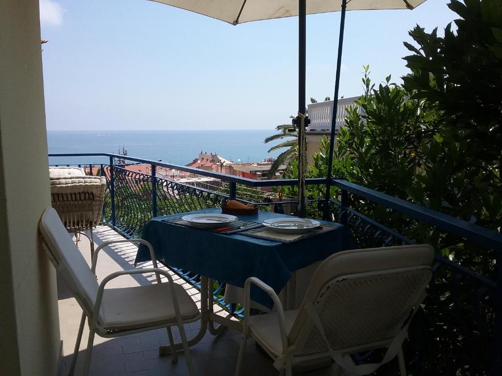 una mesa y sillas en un balcón con vistas al océano en Home Caviglia CITRA 09029-LT-0618, en Finale Ligure