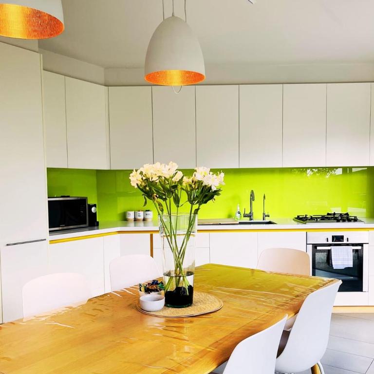 a kitchen with a wooden table with flowers on it at Fusion Townhouse-North Hobart in West Hobart