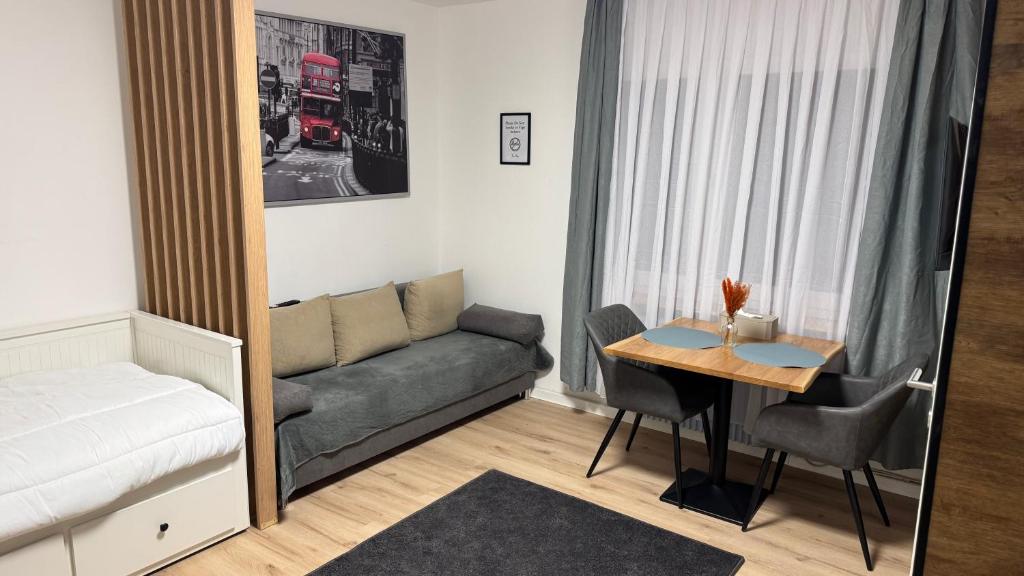a small living room with a couch and a table at Modern Compact Studio near Frankfurt in Karben