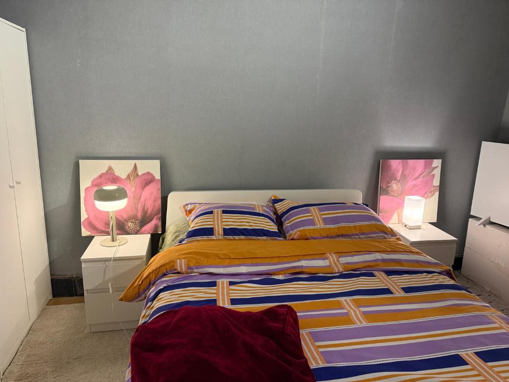 a bedroom with a bed with two night stands and two lamps at Fly City châtelet in Châtelet