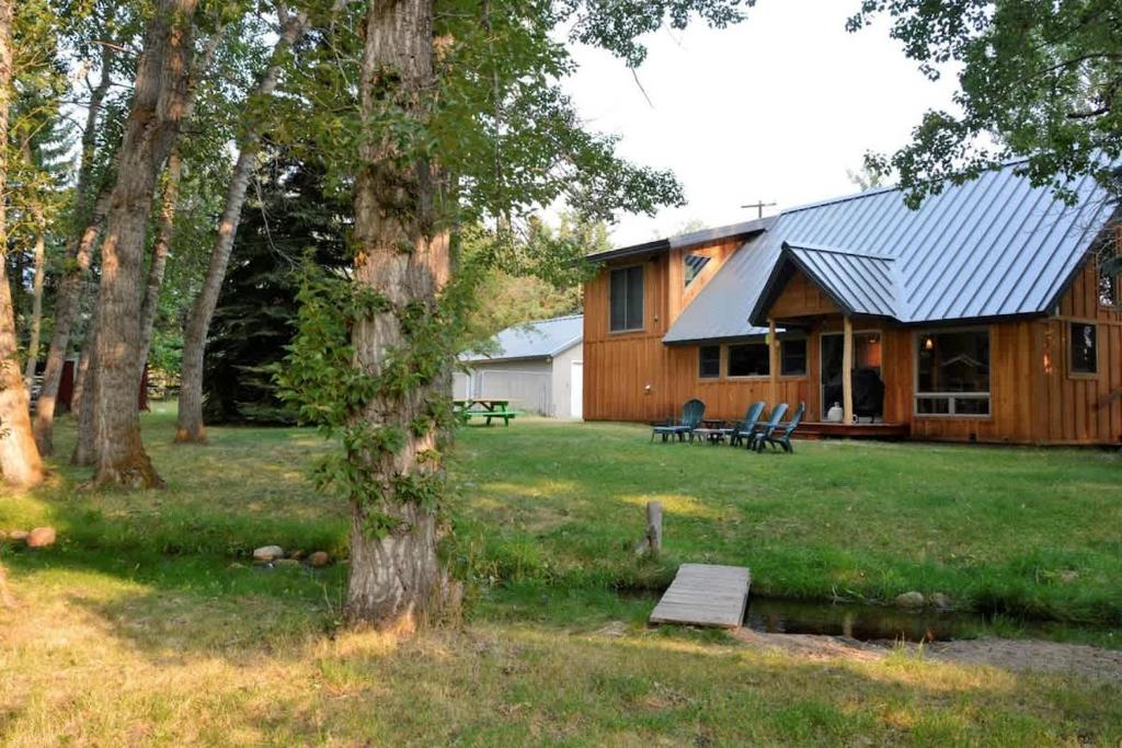 a log cabin with a picnic table in the yard at Chickadee Chalet in Red Lodge