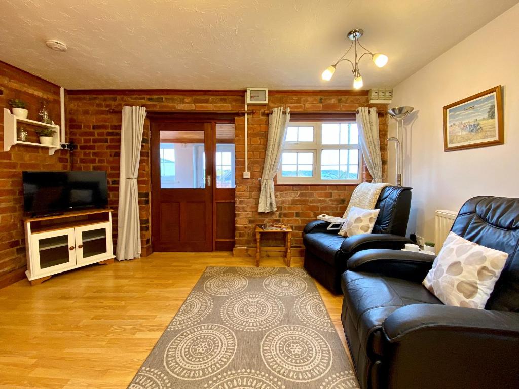 a living room with a couch and a television at Dabinett in Ledbury