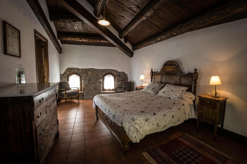 a bedroom with a bed and a dresser and two windows at Casa Parramon in Peramea