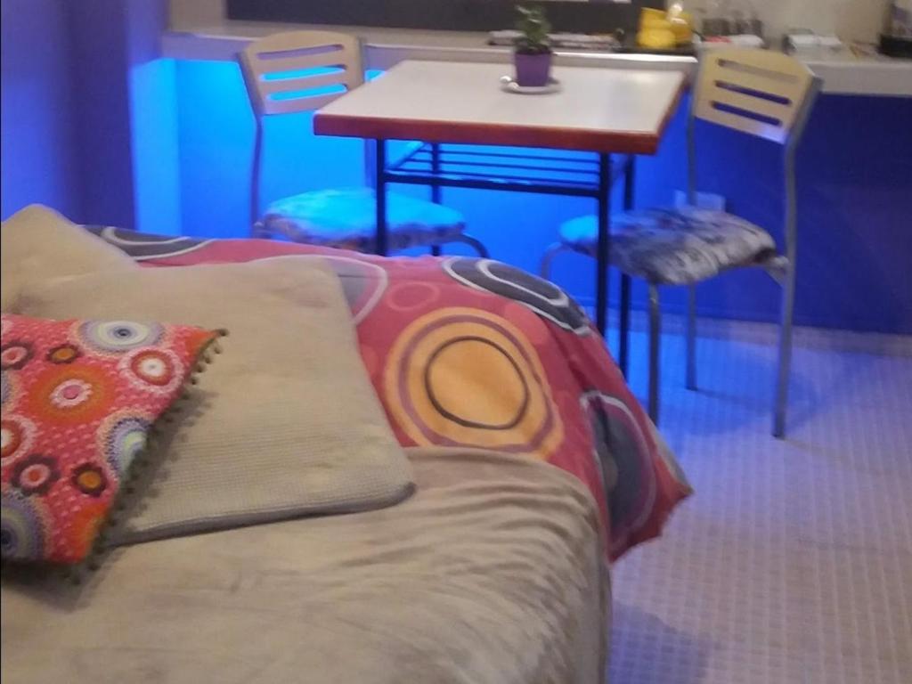 a couch with a pillow sitting next to a table at Habitación con baño privado in La Plata